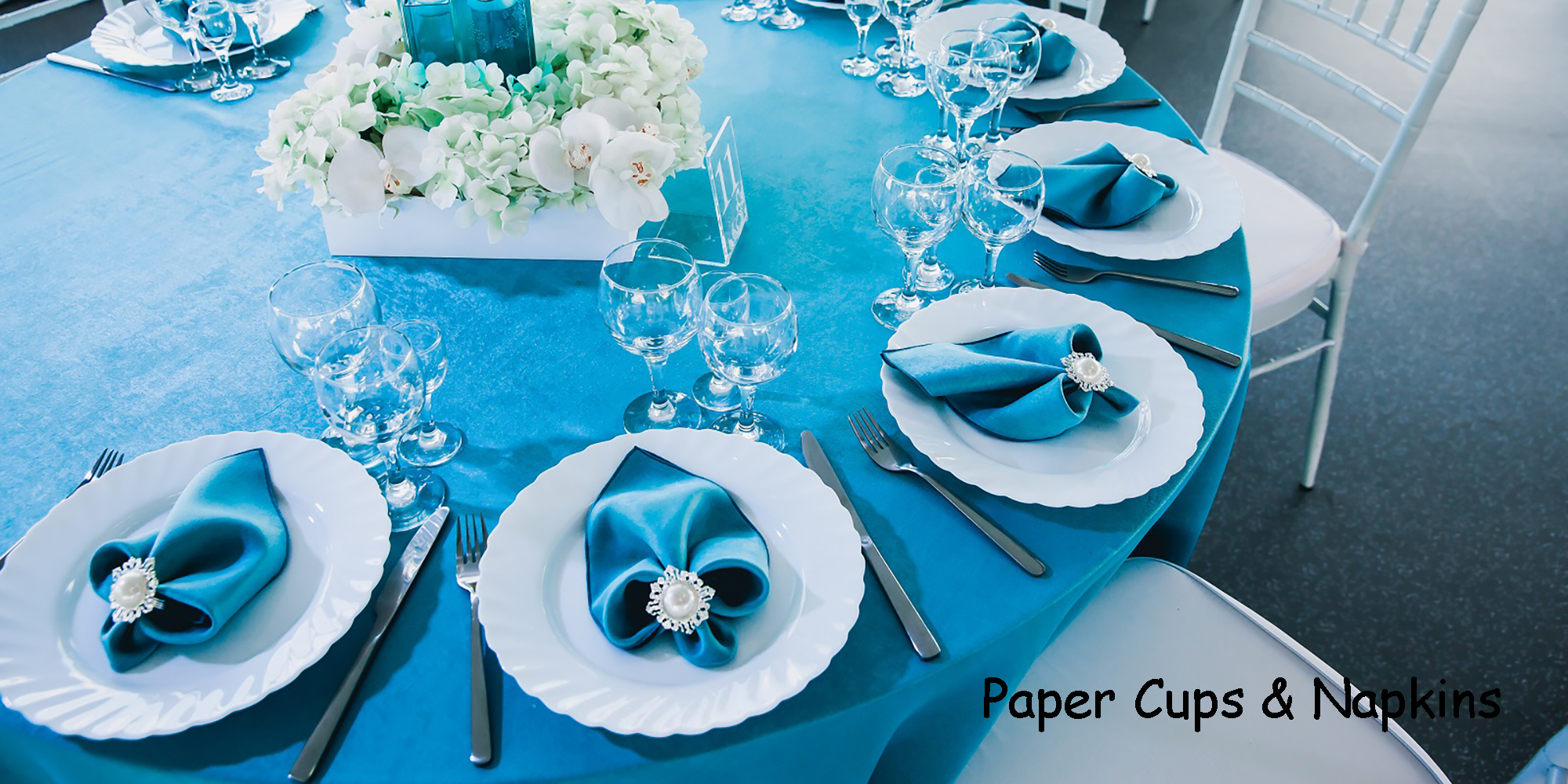 beautiful decorated restaurant at the wedding in blue and white colors, tablecloths served with tablecloth, textile napkins  orchids flowers in vases with blue water